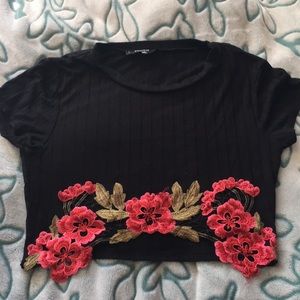 Black crop shirt with some roses on the bottom